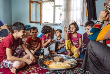 A Syrian refugee family enjoys the meal they have received from one of the soup kitchens in Gaziantep that IOM supports. Foto: IOM 2016