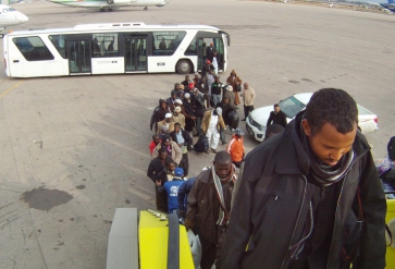 Nigeriaanse migranten stappen in een vliegtuig om terug te keren naar Nigeria. | Foto: IOM, 2012